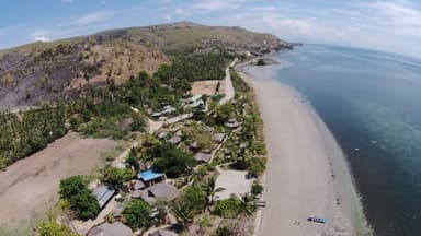 Aerial view of Beloi on Atauro, with a long beach, palms and the jetty