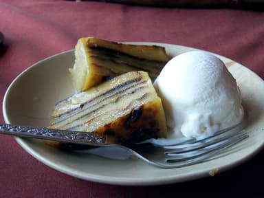 A slice of layered coconut bebinca cake with a scoop of ice cream