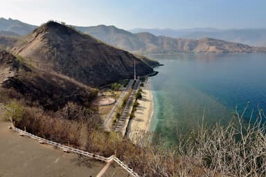 View down over Cristo Rei beach and the coast road from the steps to the statue