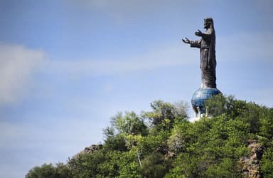 The Cristo Rei statue on its globe above the trees on Cape Fatucama, Dili