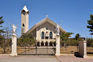 The white Immaculate Conception Cathedral in Dili with angel statues at the gate