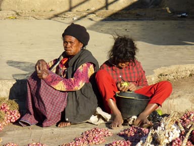 Women selling red shallots and garlic on the ground at the market in Maubisse