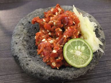 Crushed red chilli relish in a stone mortar with lime and garlic